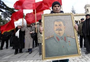 People carry red flags and a portrait of the late Soviet leader Josef Stalin during a ceremony to mark the 60th anniversary of his death in his hometown of Gori, about 80 km (50 miles) west of Georgia's capital Tbilisi March 5, 2013. REUTERS/David Mdzinarishvili