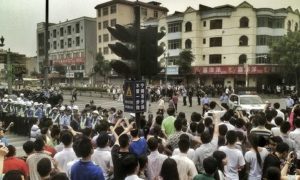 चीन में अप्रैल माह में एक फैक्ट्री के बाहर जुटे हड़ताली मज़दूर और पुलिस बल  