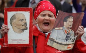 मास्‍को में मई दिवस की रैली में शामिल मज़दूर के हाथ में लेनिन व स्‍तालिन के पोस्‍टर 